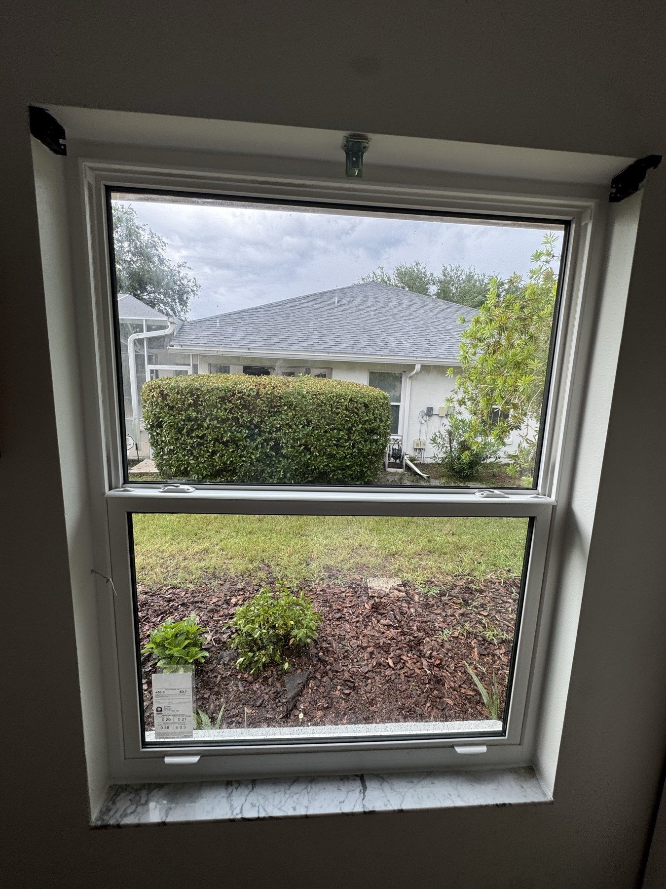 Completed window installation with teal shutters — evening