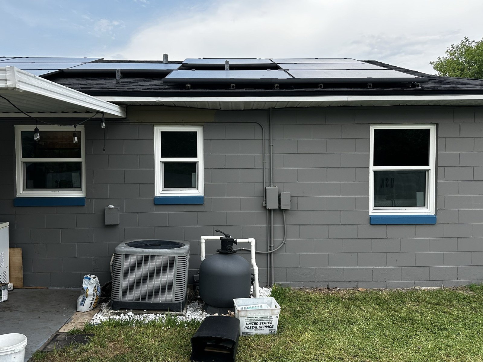 Gray concrete block home with three new impact windows installed