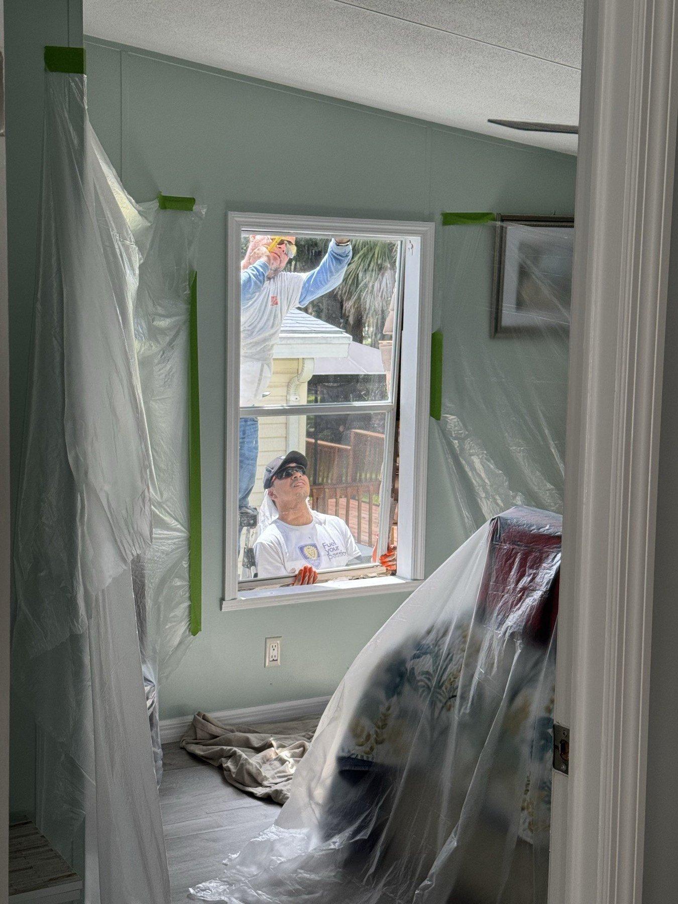 Room completely covered — worker installs window from outside